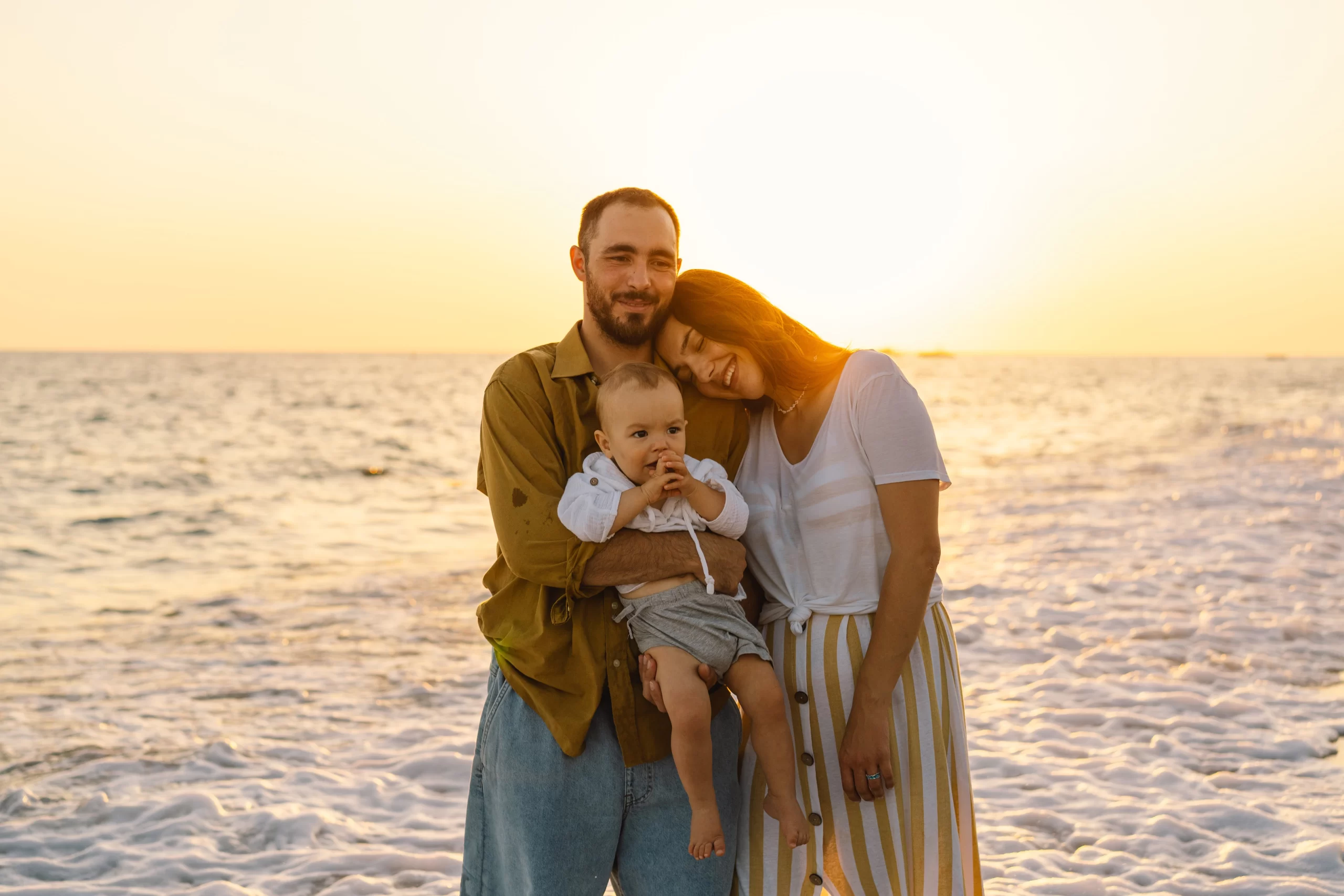 A beautiful family on the beach during sunset showcasing hidden effects of addiction on family. peak state recovery